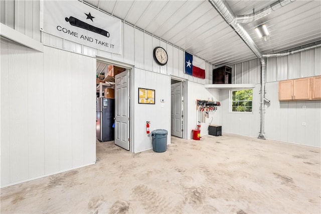 garage with stainless steel fridge and wooden walls