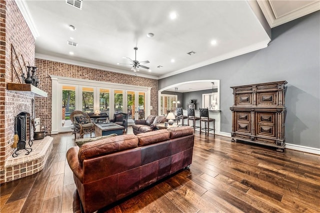 living room with crown molding, ceiling fan, french doors, and brick wall