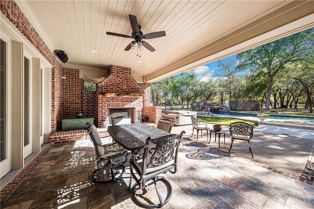 view of patio with ceiling fan, a swimming pool, and an outdoor brick fireplace