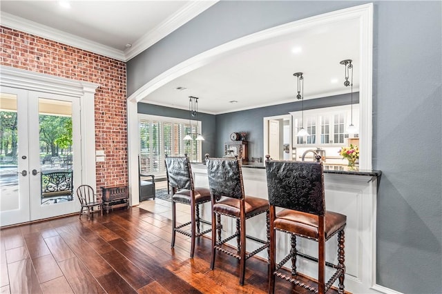 bar featuring french doors, dark hardwood / wood-style floors, ornamental molding, decorative light fixtures, and white cabinetry