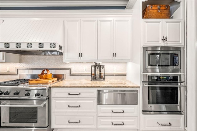 kitchen featuring decorative backsplash, appliances with stainless steel finishes, light stone counters, ventilation hood, and white cabinetry