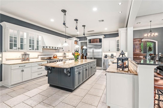 kitchen with gray cabinetry, dark stone counters, pendant lighting, white cabinets, and custom exhaust hood