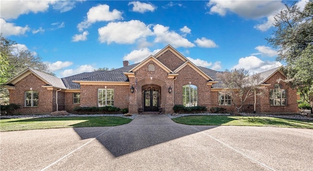 view of front of home with a front lawn and french doors