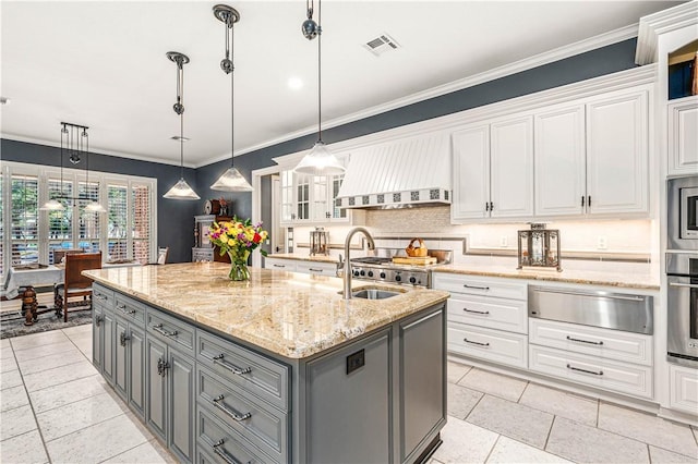 kitchen featuring gray cabinetry, a center island with sink, white cabinets, and hanging light fixtures