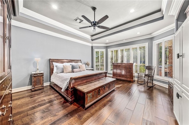 bedroom with a raised ceiling, ceiling fan, crown molding, and dark wood-type flooring