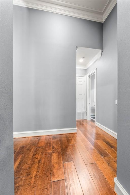 spare room featuring hardwood / wood-style floors and ornamental molding