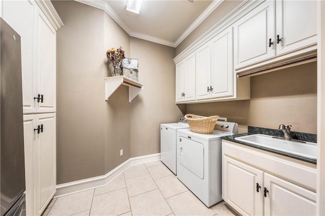 clothes washing area with cabinets, sink, separate washer and dryer, light tile patterned floors, and ornamental molding