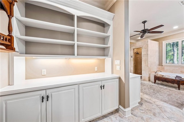 interior space featuring built in shelves, ceiling fan, and crown molding