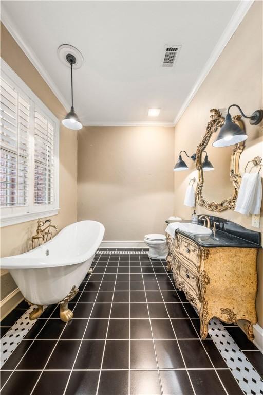 bathroom featuring a bathtub, vanity, tile patterned flooring, toilet, and ornamental molding