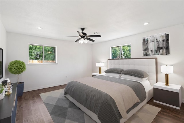 bedroom with ceiling fan, dark hardwood / wood-style flooring, and multiple windows