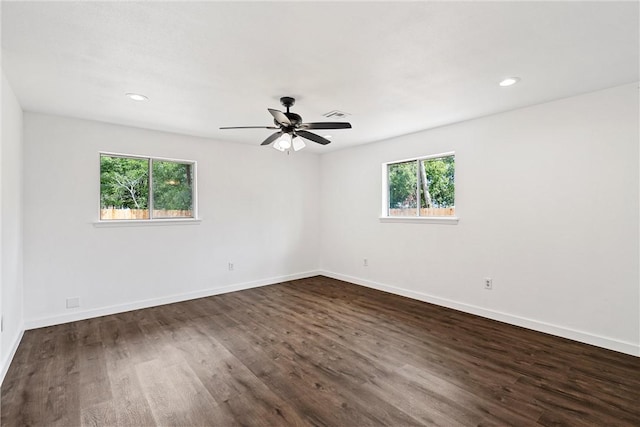 spare room featuring a wealth of natural light, dark hardwood / wood-style flooring, and ceiling fan