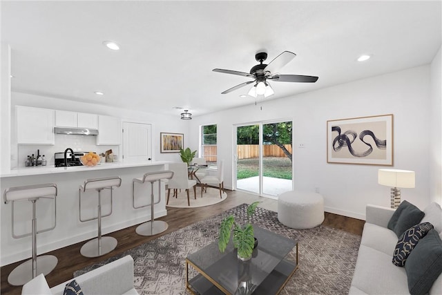 living room featuring dark hardwood / wood-style floors and ceiling fan