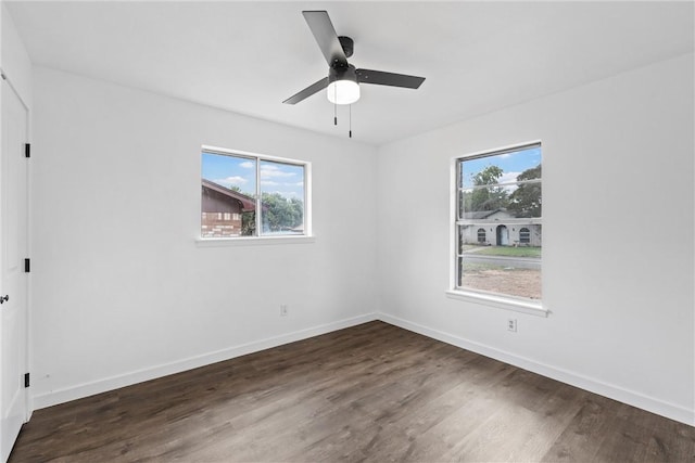 spare room featuring ceiling fan, a healthy amount of sunlight, and dark hardwood / wood-style floors