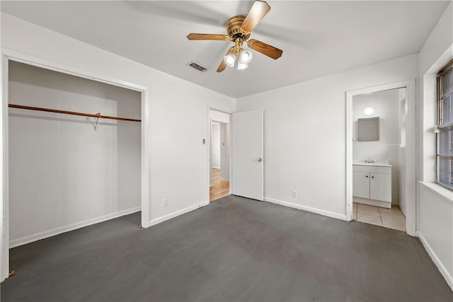 unfurnished bedroom with ceiling fan, ensuite bathroom, a closet, and dark hardwood / wood-style floors