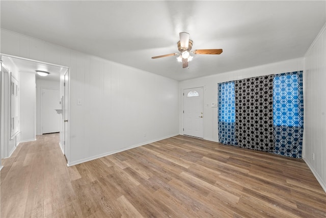 empty room with ceiling fan and light hardwood / wood-style flooring