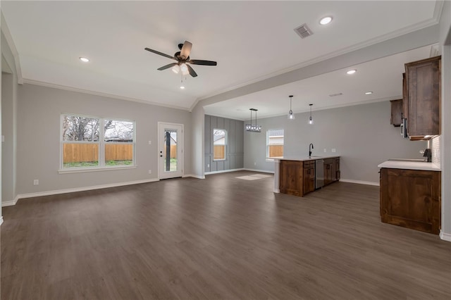 unfurnished living room featuring dark hardwood / wood-style flooring, ceiling fan, crown molding, and sink