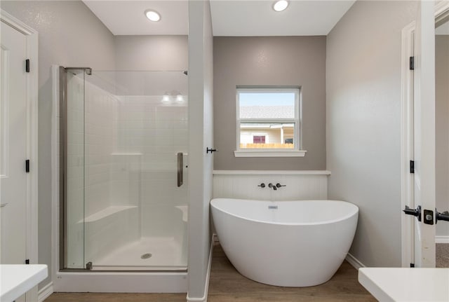 bathroom featuring hardwood / wood-style floors and plus walk in shower