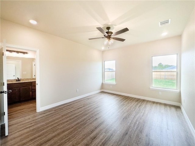 unfurnished room with ceiling fan, hardwood / wood-style floors, and sink