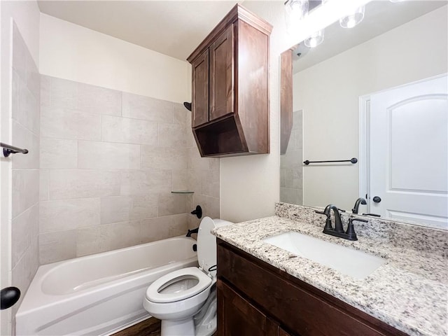 full bathroom with vanity, tiled shower / bath, and toilet