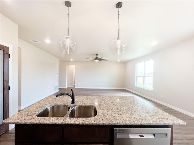 kitchen featuring stainless steel dishwasher, pendant lighting, a center island with sink, and sink