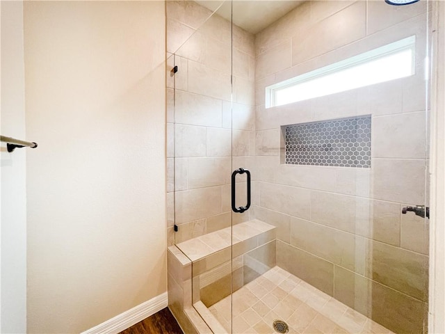 bathroom featuring a shower with door and hardwood / wood-style flooring