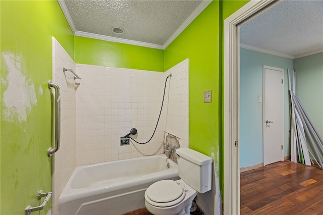 bathroom featuring hardwood / wood-style floors, crown molding, tiled shower / bath combo, toilet, and a textured ceiling