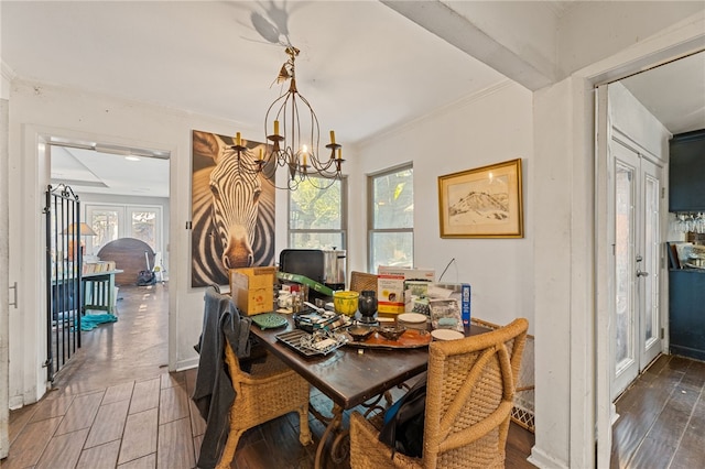 dining area with a healthy amount of sunlight, french doors, dark wood-type flooring, and an inviting chandelier