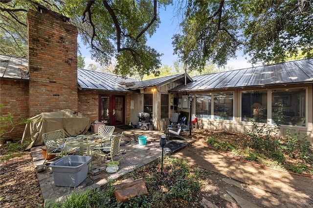 rear view of house with a patio and a sunroom