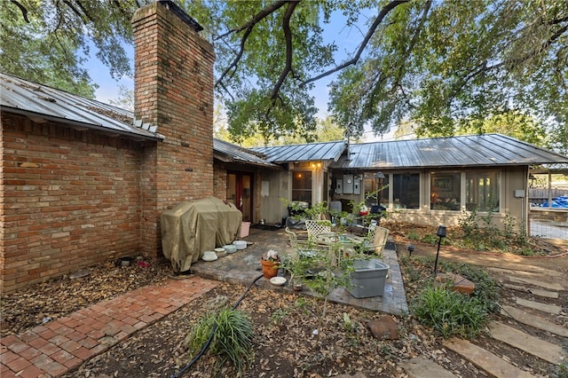 back of house with a patio area and a sunroom