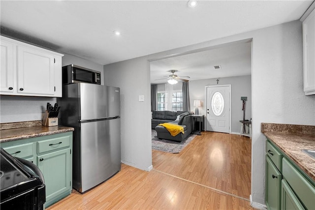 kitchen with appliances with stainless steel finishes, green cabinets, light hardwood / wood-style flooring, and white cabinets