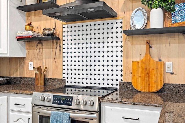 kitchen featuring white cabinets, ventilation hood, high end stainless steel range oven, and dark stone counters