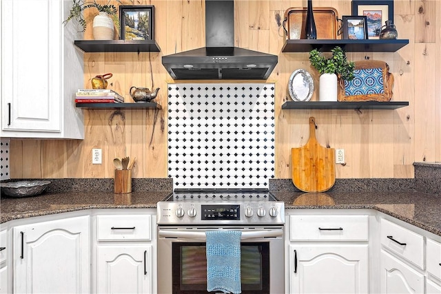 kitchen featuring white cabinets, dark stone counters, stainless steel range with electric cooktop, and range hood