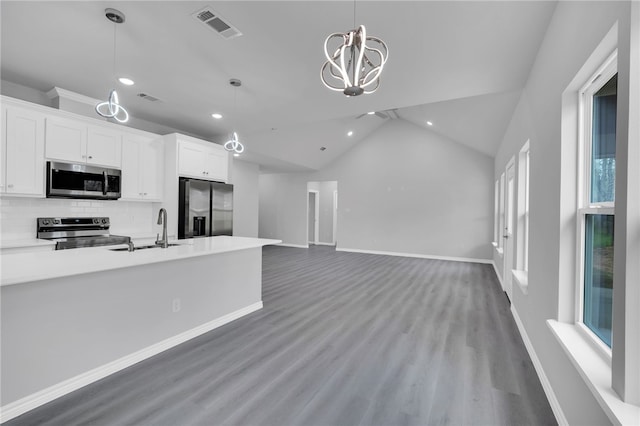 kitchen featuring lofted ceiling, sink, appliances with stainless steel finishes, tasteful backsplash, and white cabinetry