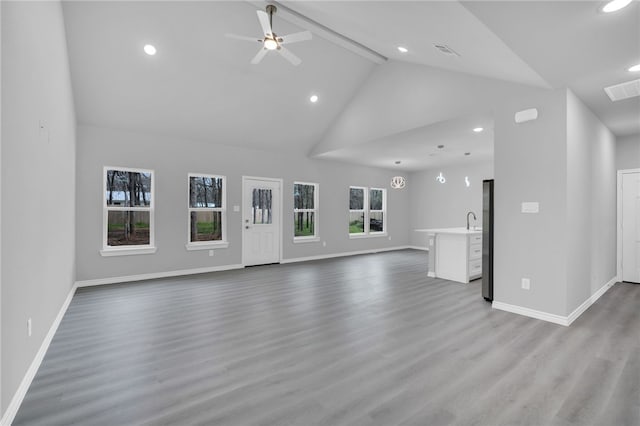 unfurnished living room with plenty of natural light, light wood-type flooring, and high vaulted ceiling