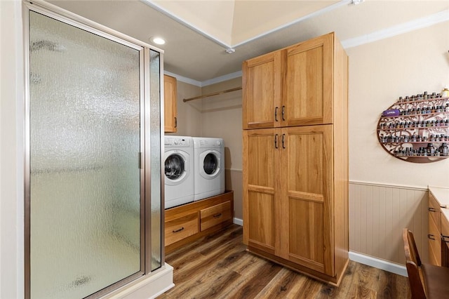 laundry room with washing machine and clothes dryer, ornamental molding, and dark hardwood / wood-style flooring