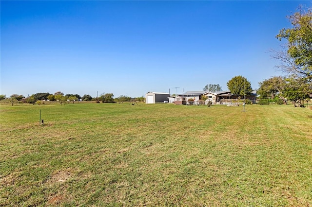 view of yard with a rural view and a shed