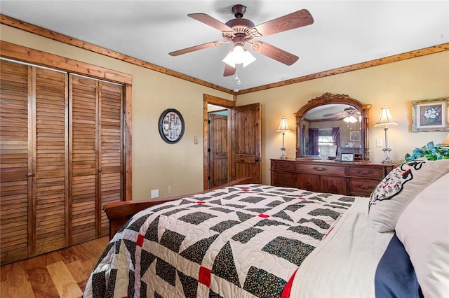 bedroom with crown molding, light hardwood / wood-style floors, a closet, and ceiling fan