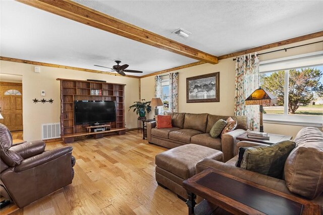 living room with beam ceiling, light hardwood / wood-style floors, and ceiling fan