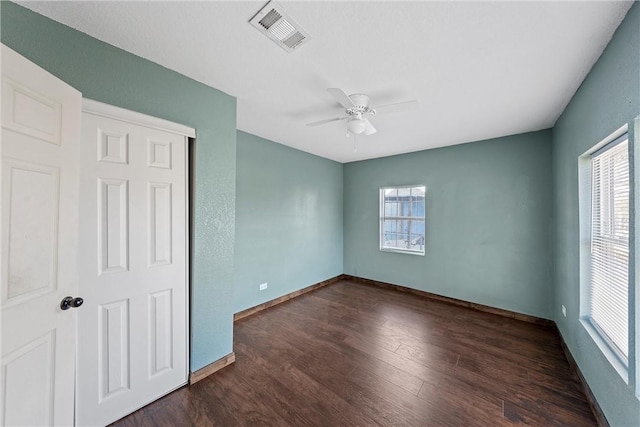 unfurnished bedroom featuring ceiling fan, dark hardwood / wood-style flooring, and a closet