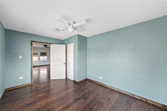 empty room featuring ceiling fan and dark hardwood / wood-style flooring