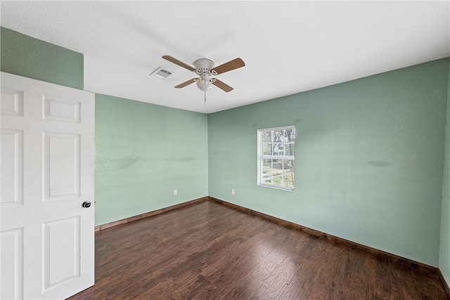 spare room with ceiling fan and dark hardwood / wood-style flooring