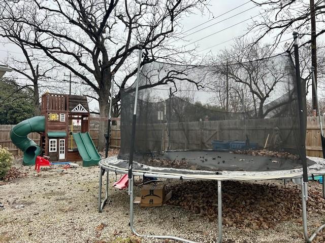 view of yard featuring a playground and a trampoline