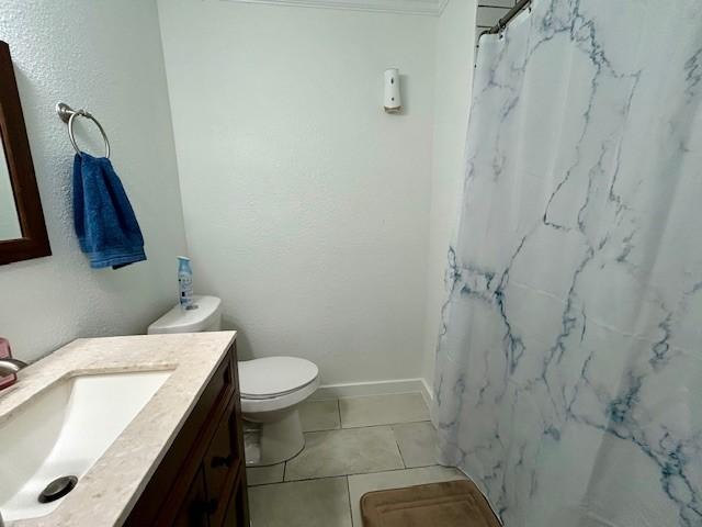 bathroom featuring tile patterned flooring, vanity, curtained shower, and toilet