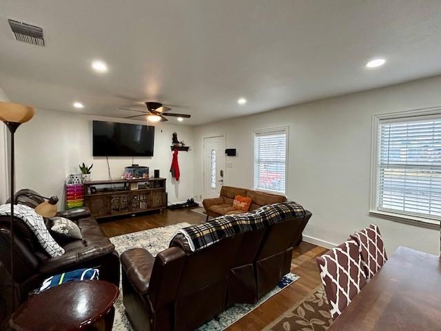 living room with dark wood-type flooring and ceiling fan