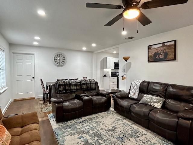 living room with wood-type flooring and ceiling fan