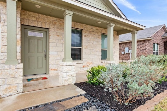 doorway to property featuring stone siding and covered porch