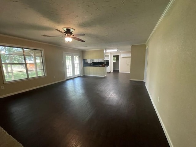 unfurnished living room featuring baseboards, ornamental molding, dark wood-style flooring, and french doors