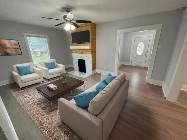 living room featuring hardwood / wood-style flooring, a stone fireplace, and ceiling fan