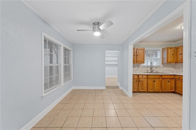 kitchen featuring backsplash, ornamental molding, ceiling fan, sink, and light tile patterned floors