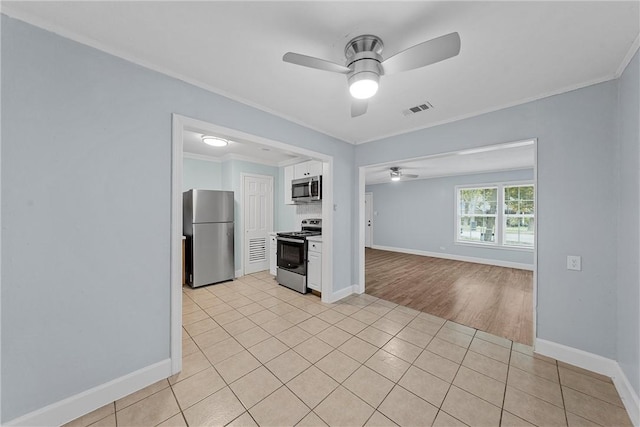 kitchen with appliances with stainless steel finishes, light hardwood / wood-style floors, ceiling fan, and crown molding